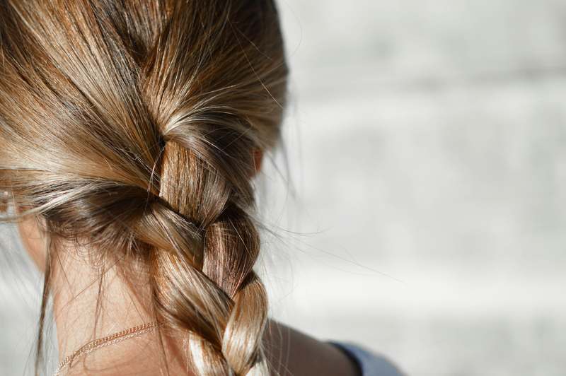 Editorial-style photo of diverse hands styling twisted hair